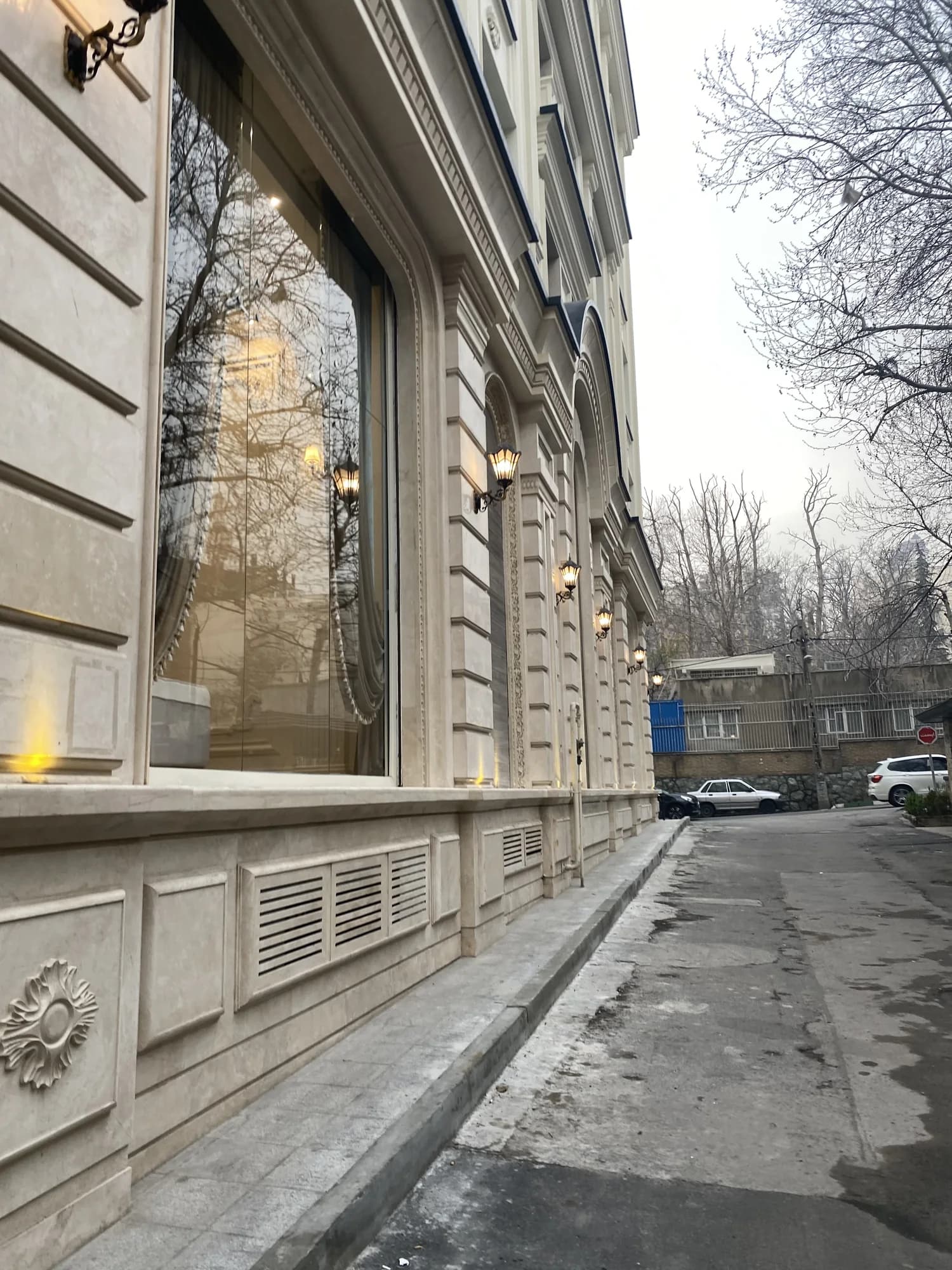 جزئیات پنجرهٔ بلند و جدارهٔ سنگی در تراز خیابانِ پروژهٔ الهیه